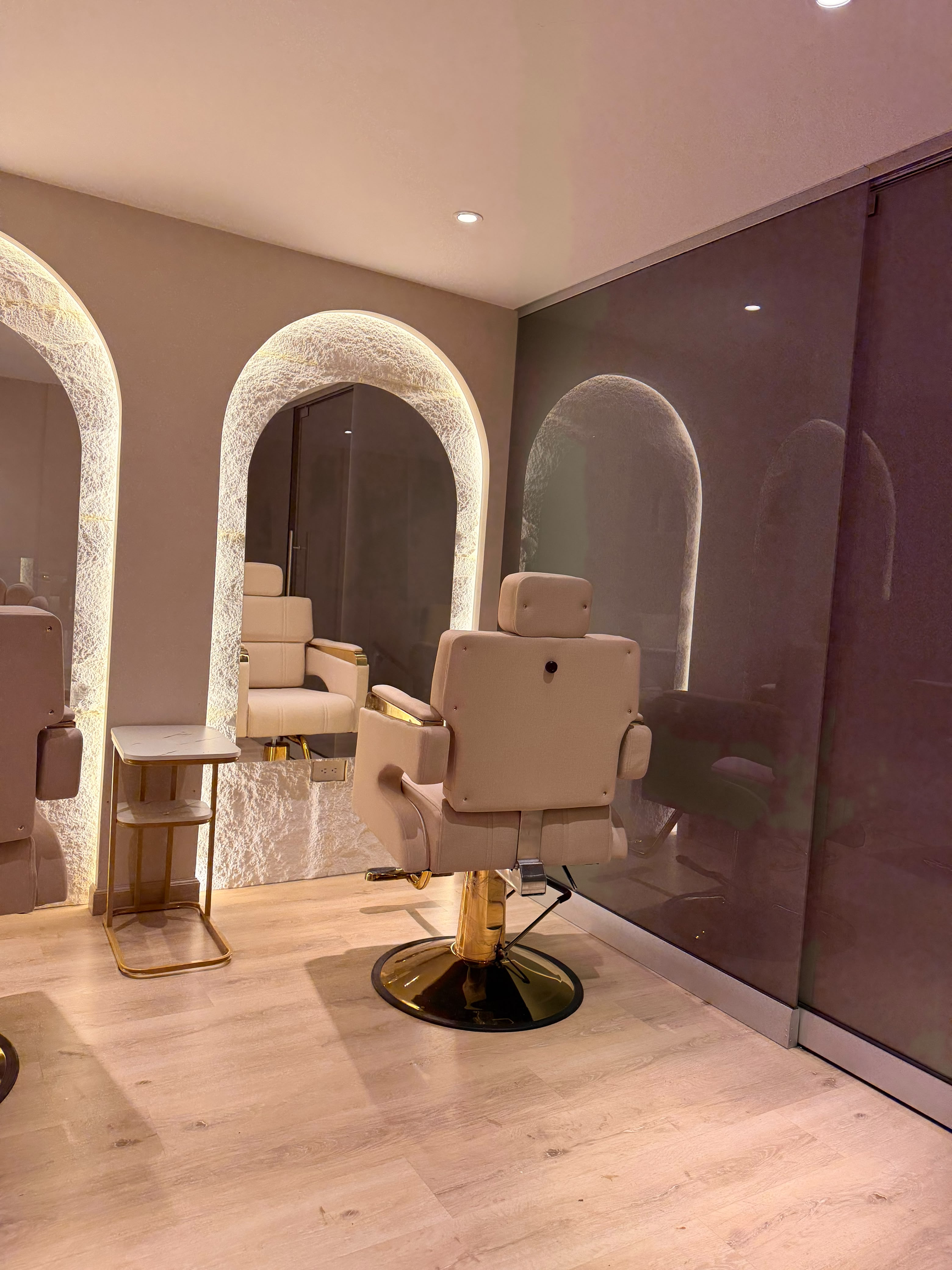 Sala de belleza con espejos iluminados y acabados dorados en Coco Cali